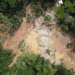 Evading Taxes, Miners Leave Behind Death Traps and Polluted River Drone shot of Golden Trip's mine in Kpeteyea